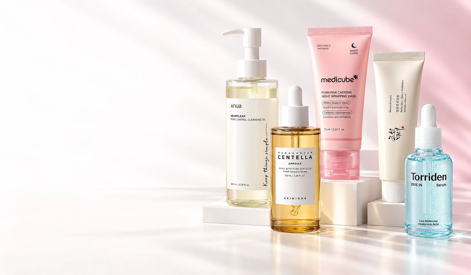 Anua, SKIN1004, Medicube, Beauty of Joseon and Torriden skincare arranged on a softly lit product display.